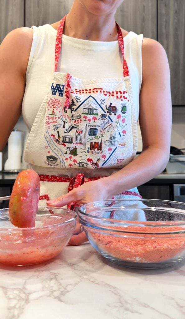 dipping gluten free donuts in strawberry glaze