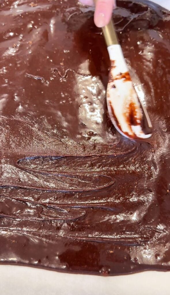 spreading brownie batter for gluten free ice cream sandwiches